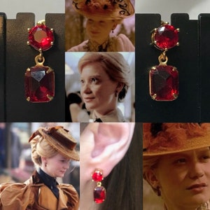 Peut inclure: Boucles d'oreilles pendantes dorées avec une pierre rouge facettée ronde en haut et une pierre rouge facettée rectangulaire en bas. Les boucles d'oreilles sont présentées sur un fond noir, avec des images des boucles d'oreilles portées par une personne.