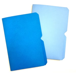 May include: Two blue file folders, one in a vibrant shade of blue and the other in a lighter, pastel blue. Both folders have a standard notched design on the right side. The folders are made of a textured paper material.