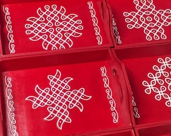 May include: Set of six red wooden trays with white intricate designs. The trays have a decorative border and a handle on each side.