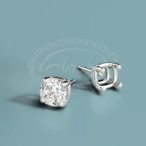 May include: A pair of silver stud earrings with a clear round gemstone in one earring and an empty setting in the other.
