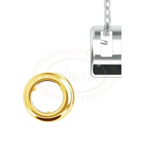 May include: A gold-colored, circular jewelry component with a central opening, positioned next to a silver-colored, rectangular pendant suspended by a chain. The pendant has a small, rectangular cutout.