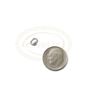 K&ouml;nnte beinhalten: Ein kleiner silberner Drehverschluss, etwa so gro&szlig; wie eine Zehn-Cent-M&uuml;nze, zum Anbringen von Schmuck oder anderen Gegenst&auml;nden.