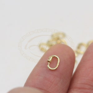 K&ouml;nnte beinhalten: Goldfarbener Metall-Hummerverschluss, eine Art von Schmuckzubeh&ouml;r, das zum Verbinden von Ketten oder Schn&uuml;ren verwendet wird.