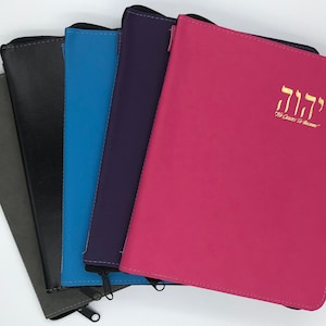 May include: Five zippered pouches in different colours: grey, black, blue, purple, and pink. The pink pouch has the Hebrew word "L'dor V'dor" in gold lettering, which translates to "For Generations to Come."
