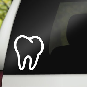 May include: A white outline of a tooth on a black car window.