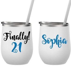May include: Two white stainless steel wine tumblers with lids and straws. One tumbler says "Finally! 21" in black with the number 21 in blue. The other tumbler says "Sophia" in blue cursive.