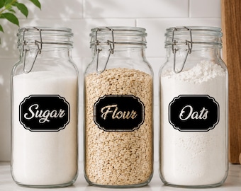 May include: Three clear glass storage jars with metal wire-bail lids. Each jar features a black rectangular label with decorative edges and white cursive text reading Sugar, Flour, and Oats, filled with their respective dry ingredients.