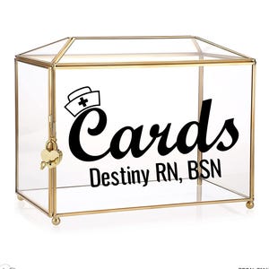 May include: A clear glass card box with gold trim and a heart-shaped lock. The box features the word "Cards" in a bold, black script, along with a nurse's hat icon and the name "Destiny RN, BSN".