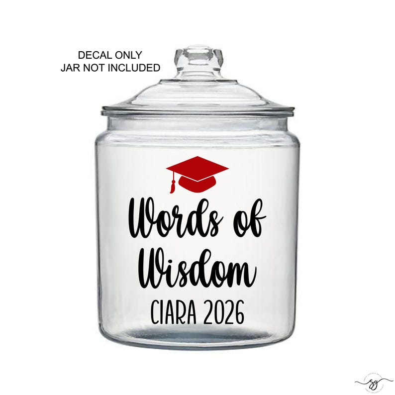 May include: A clear glass jar with a lid, featuring a red graduation cap graphic and the words "Words of Wisdom CIARA 2026" in black script. The text "DECAL ONLY JAR NOT INCLUDED" is at the top.