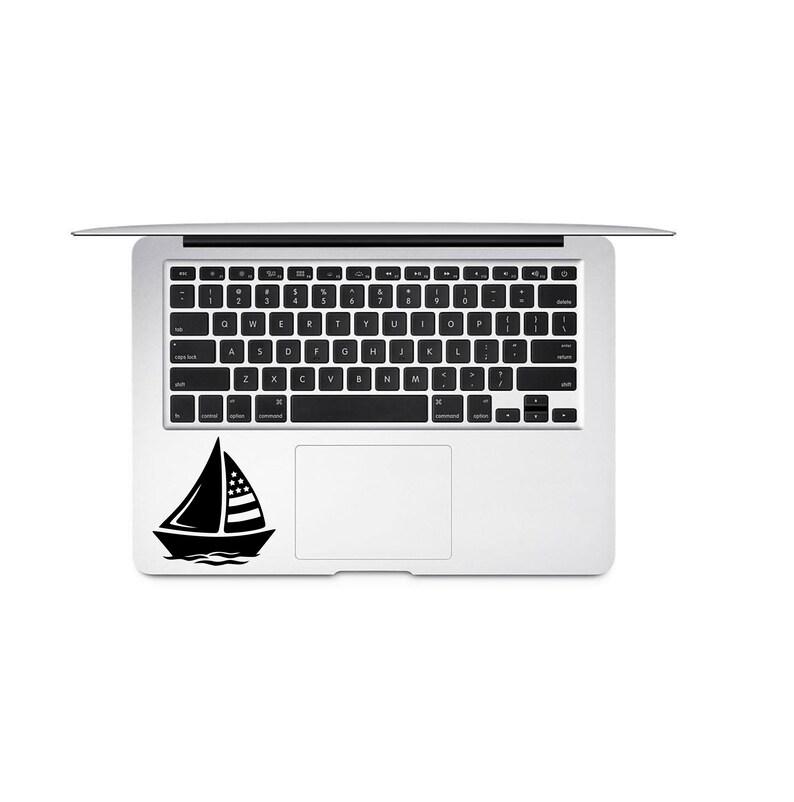 May include: A black and white sailboat sticker on a silver laptop computer.