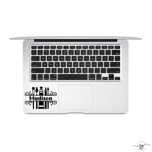 May include: A black and white laptop sticker with a design of art supplies and the name "Madison" in a decorative font.