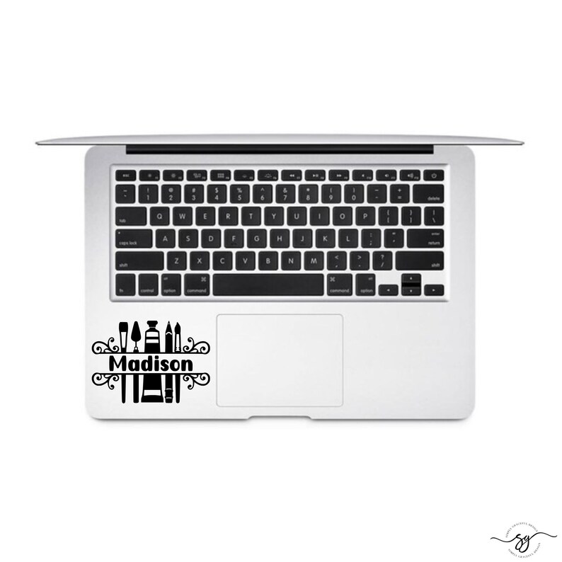 May include: A black and white laptop sticker with a design of art supplies and the name "Madison" in a decorative font.
