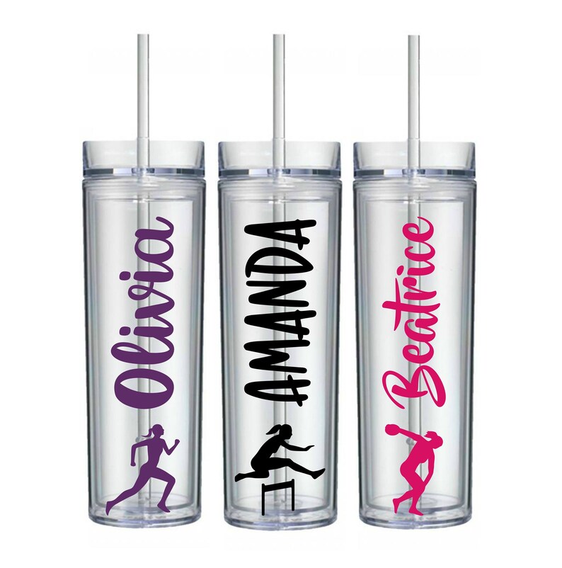 May include: Three clear plastic tumblers with straws. Each tumbler has a different name on it: Olivia, Amanda, and Beatrice. The names are in different colors and fonts. Each tumbler also has a silhouette of a woman running on it.