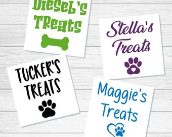 May include: Four square white labels featuring personalized text and pet-themed icons. One label has green text reading Diesel's Treats with a bone icon. Another has purple text reading Stella's Treats with a paw print. One has black text reading TUCKER'S TREATS with a paw print. The last has blue text reading Maggie's Treats with a heart and paw print icon.