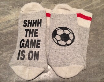 Shhh The Game Is On .... (Soccer Ball Silhouette) (Word Socks - Funny Socks - Novelty Socks)