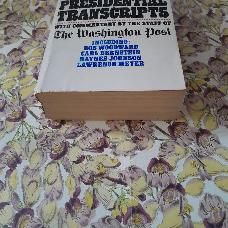 May include: A book titled "Presidential Transcripts" with commentary by The Washington Post. The cover is white with black text and includes the names Bob Woodward, Carl Bernstein, Haynes Johnson, and Lawrence Meyer.
