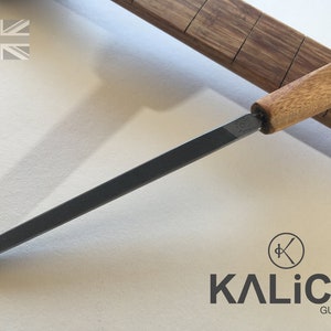 May include: A black metal file with a wooden handle. The handle is labeled "Kalico".