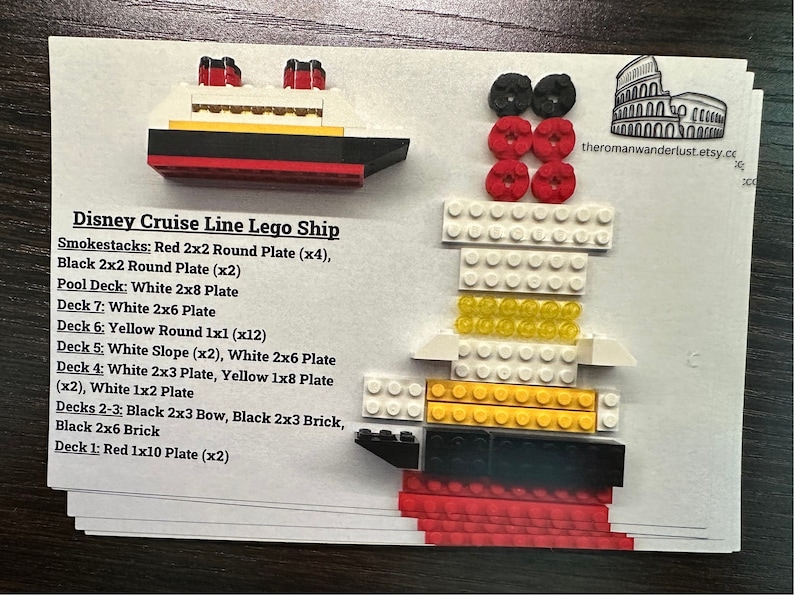 May include: A Disney Cruise Line Lego ship model, constructed from various colored Lego bricks. The model includes red, black, yellow, and white components, with text detailing the Lego pieces used. The ship features smokestacks, decks, and a bow.