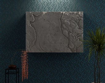 May include: A gray textured canvas painting with a dark blue floral wallpaper background. A small potted plant with green leaves is on the right side of the image. A small black metal stand with a potted plant with pink flowers is on the left side of the image.