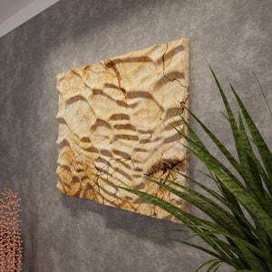 May include: A beige and brown textured wall art piece with a wavy pattern. The art is made of stone and has a natural, organic look.