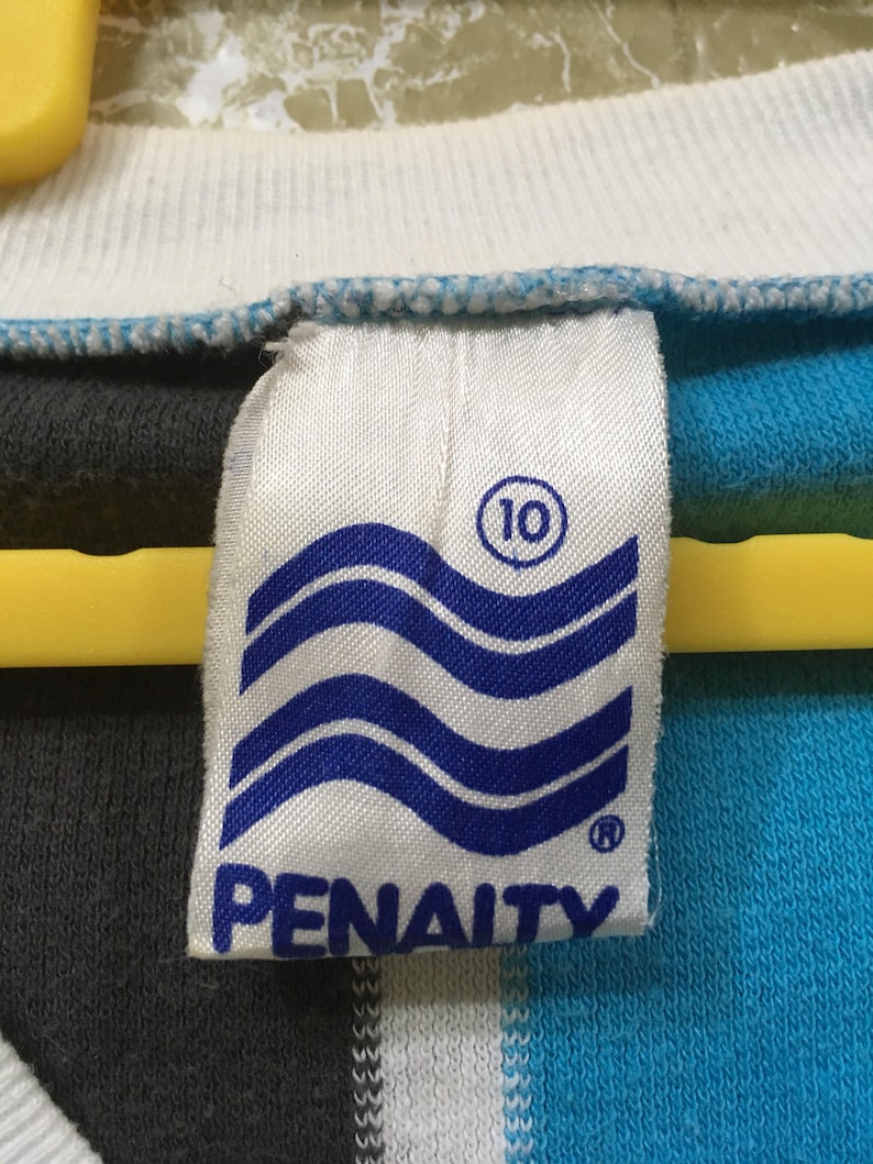 May include: A white tag with blue waves and the word "PENALTY" in blue lettering. The tag also has a circle with the number "10" inside.