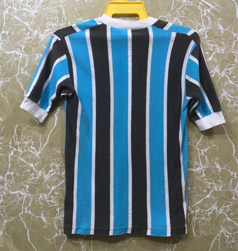 May include: A striped short-sleeved shirt with blue and black vertical stripes. The shirt has a white collar and cuffs.