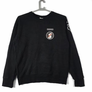 May include: Black long-sleeve sweatshirt with a white graphic of a lightning bolt inside a circle with the text "COLUMBUS" above it.
