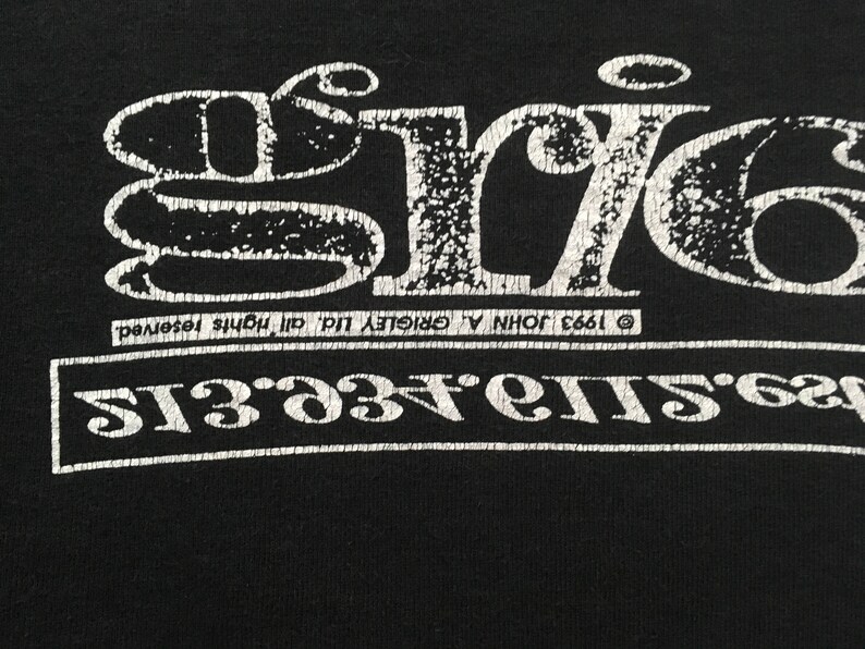May include: Black t-shirt with a distressed white graphic. The graphic features the word "ERIC" in a stylized font above a line of text. The text includes the year 1993 and the phrase "all rights reserved."