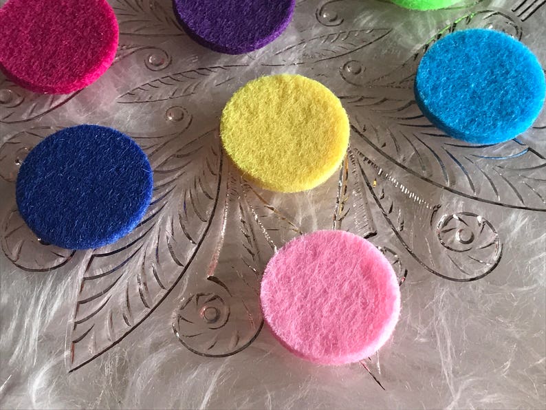 Peut inclure: Assortiment de cercles en feutre de diff&eacute;rentes couleurs, rose, bleu, jaune, violet et bleu clair, dispos&eacute;s sur une surface blanche textur&eacute;e.