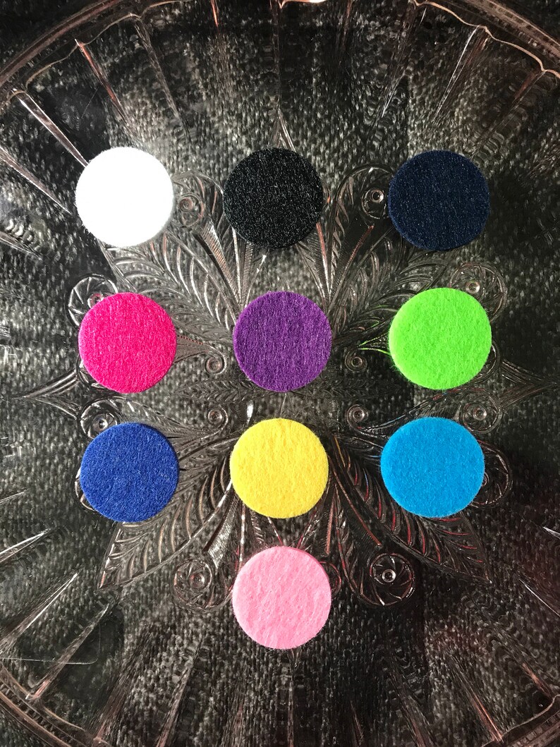 Peut inclure: Neuf cercles en feutre de diff&eacute;rentes couleurs, dont blanc, noir, bleu marine, rose, violet, vert, jaune et bleu clair. Les cercles sont dispos&eacute;s en cercle sur un fond argent&eacute;.