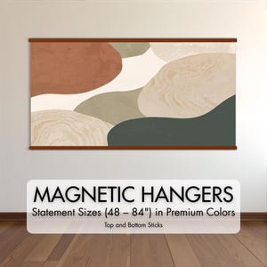 May include: Abstract art print with a brown wooden magnetic hanger. The artwork features organic shapes in shades of brown, beige, green, and cream. The text "MAGNETIC HANGERS" is displayed below the artwork, with size details.
