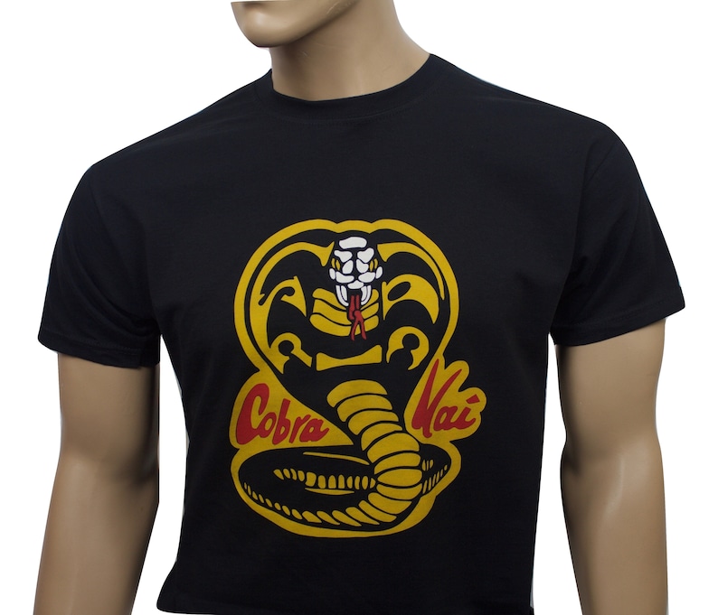 May include: Black t-shirt with a yellow cobra graphic and the text "Cobra Kai" in red and yellow lettering.