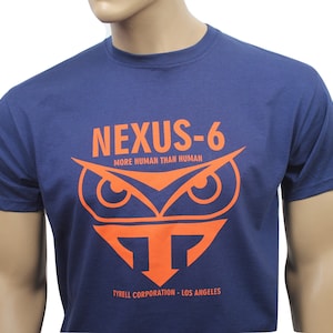 May include: A navy blue t-shirt with an orange graphic of an owl with the text "NEXUS-6 MORE HUMAN THAN HUMAN TYRELL CORPORATION - LOS ANGELES"