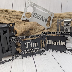 May include: Four personalized multi-tool credit card sized pocket knives. The knives are black and silver with various tools including a bottle opener, ruler, can opener, and a butterfly wrench. The knives are engraved with the names "Sean", "Tim", "Charlie", and "My bottle opener is better than yours!"