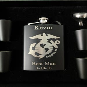 May include: A black metal flask with an engraved Marine Corps emblem, the words "Semper Fi", "Best Man", and the date "3-18-18". The flask is in a black gift box with four shot glasses and a funnel.