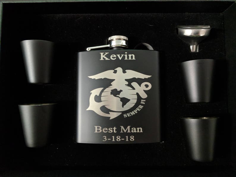 May include: A black metal flask with an engraved Marine Corps emblem, the words "Semper Fi", "Best Man", and the date "3-18-18". The flask is in a black gift box with four shot glasses and a funnel.