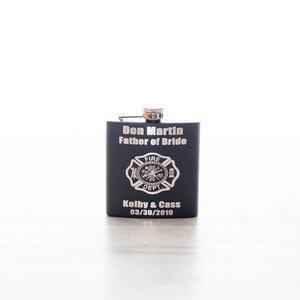 K&ouml;nnte beinhalten: Schwarze Metallflasche mit einem silbernen, gravierten Feuerwehr-Emblem, dem Text "Don Martin Father of Bride" und dem Datum "03/30/2019".