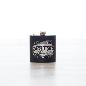 K&ouml;nnte beinhalten: Schwarze Metallflasche mit silbernem Deckel und silbernem Design, auf dem "Fog Juice" und "Distilled in Your Dream" steht.