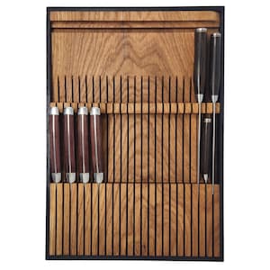 May include: A wooden knife block with a black frame and slots for holding knives. The block has a light brown wood finish and is filled with a variety of knives.