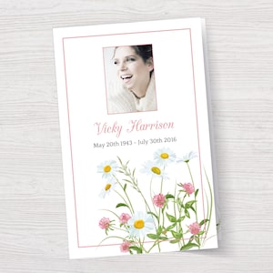 Könnte beinhalten: Eine weiße Karte mit rosa Rand und einem Foto einer lächelnden Frau. Der Text auf der Karte lautet "Vicky Harrison 20. Mai 1943 - 30. Juli 2016". Die Karte ist mit weißen Gänseblümchen und rosa Klee verziert.