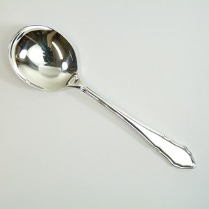 May include: A silver soup spoon with a rounded bowl and a decorative handle.