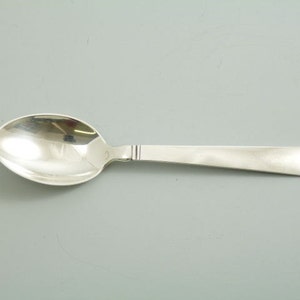 May include: A silver teaspoon with a rounded bowl and a long, slender handle.