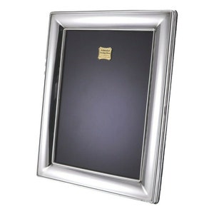May include: A silver picture frame with a bevelled edge and a polished finish. The frame has a small gold label that reads "Hallmarked Sterling Silver 925".