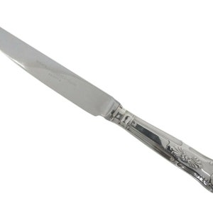 Könnte beinhalten: Ein silbernes Essmesser mit einem verzierten Griff. Die Klinge ist glatt und der Griff hat ein dekoratives Design.