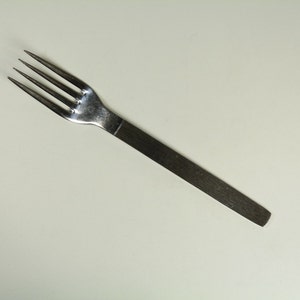 May include: A silver fork with a long, thin handle.