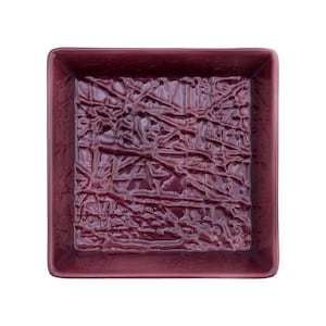 May include: A square, burgundy ceramic dish with a textured, raised design. The dish is empty.