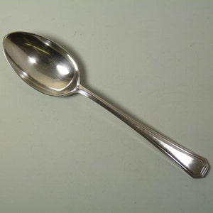 May include: A silver spoon with a rounded bowl and a simple, elegant design.