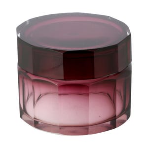 May include: A translucent, deep purple glass jar with a faceted, octagonal design. The container features a matching removable lid with a flat top and angled sides, creating a geometric silhouette that catches light through its dark violet hue.