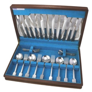 May include: A wooden box with a blue velvet lining containing a set of silverware. The silverware includes knives, forks, and spoons. The box is open and the silverware is arranged in rows.