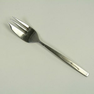May include: A silver fork with a simple design. The fork has three tines and a slightly curved handle.